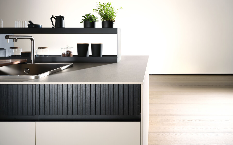 Basi della collezione Kalì in laminato beige suede con cassetti della collezione Asia in impiallacciato lava con lavorazione millerighe